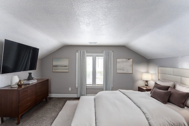 carpeted bedroom with lofted ceiling and a textured ceiling