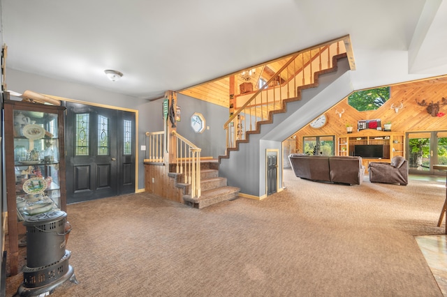 carpeted entrance foyer with a wealth of natural light and wood walls