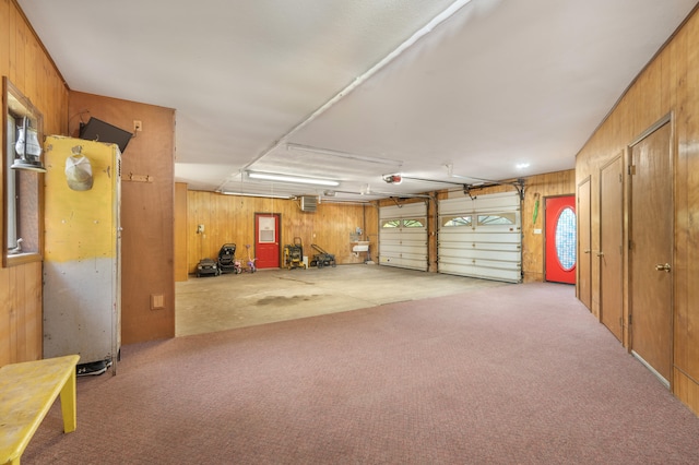 garage featuring a garage door opener and wooden walls