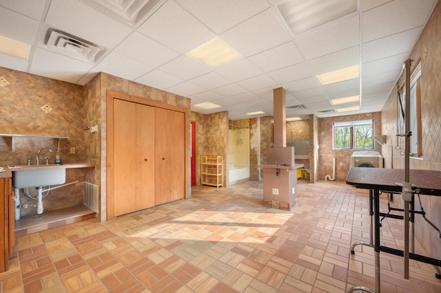 interior space featuring a paneled ceiling, washer / clothes dryer, and sink