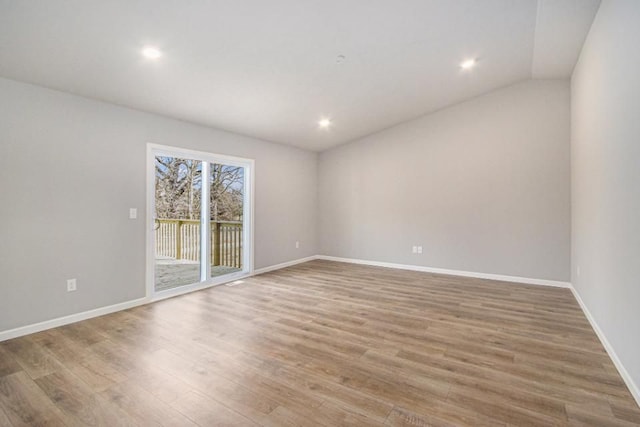 empty room featuring hardwood / wood-style floors and vaulted ceiling