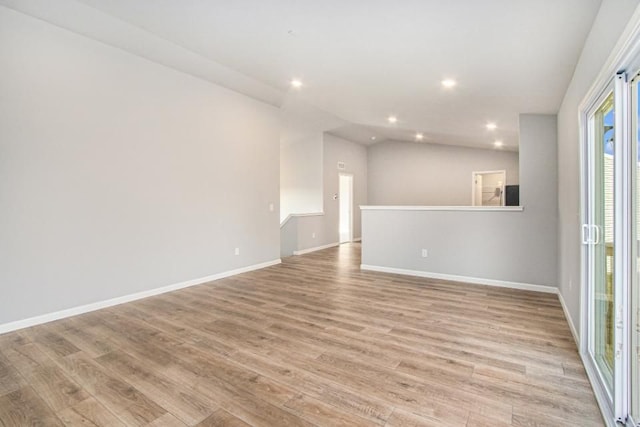 unfurnished living room with lofted ceiling and light wood-type flooring