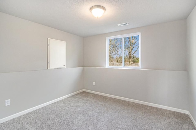 carpeted empty room featuring lofted ceiling and a textured ceiling