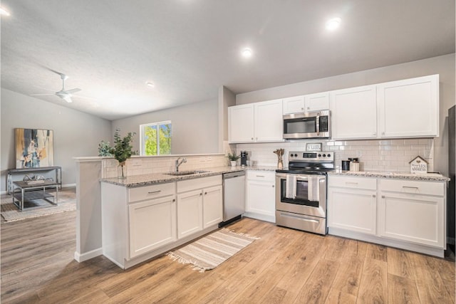 kitchen with white cabinets, sink, kitchen peninsula, and stainless steel appliances