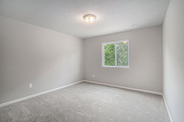 carpeted spare room with a textured ceiling