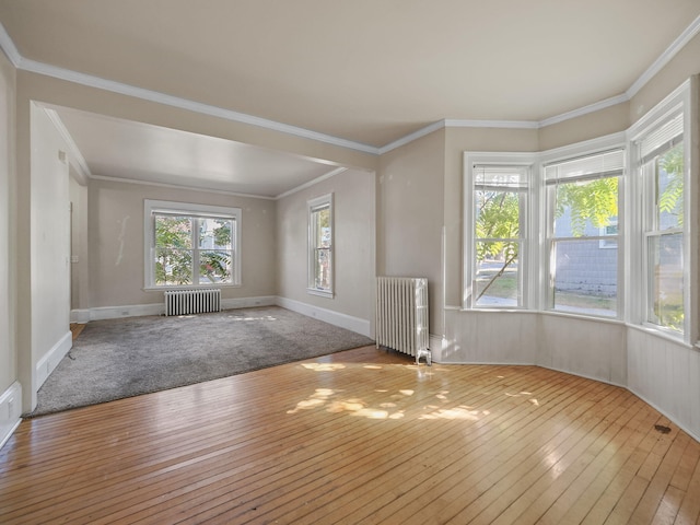 interior space with light hardwood / wood-style floors, ornamental molding, and radiator