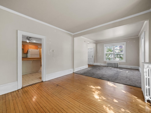 interior space featuring light hardwood / wood-style floors, radiator heating unit, and ornamental molding