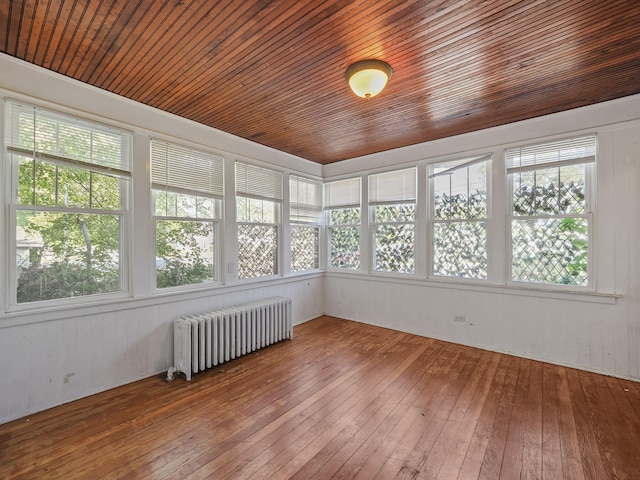 unfurnished sunroom with radiator heating unit, wood ceiling, and plenty of natural light