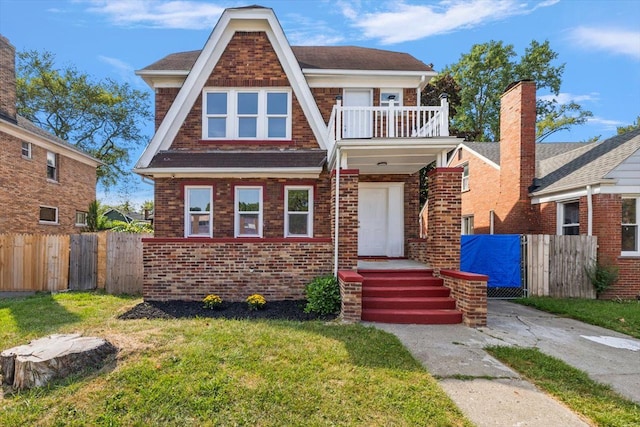 view of front of home with a balcony and a front lawn