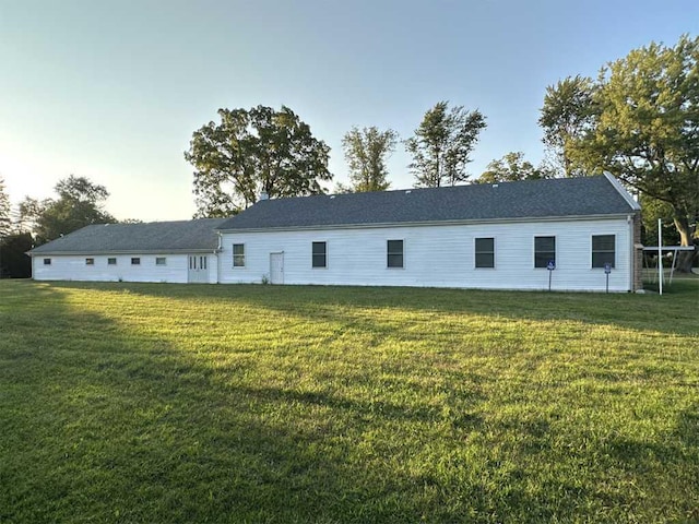 rear view of property featuring a lawn