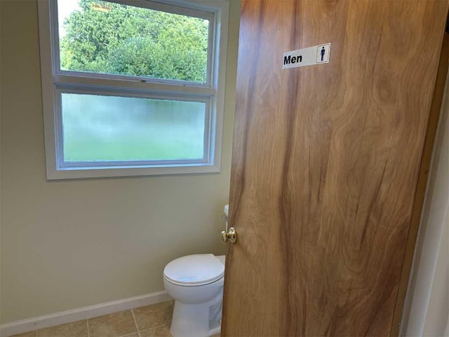 bathroom featuring tile patterned flooring, toilet, and a healthy amount of sunlight