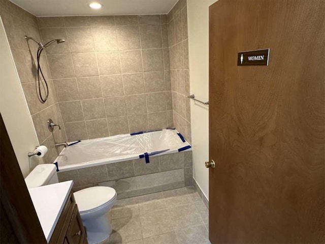 full bathroom with tile patterned flooring, vanity, tiled shower / bath combo, and toilet