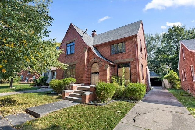 tudor-style house featuring a front yard