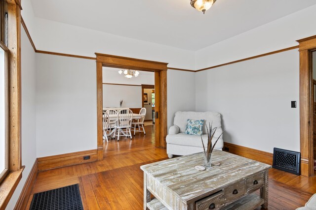 5721 Broomhead Rd, Williamsburg, MI 49690 - living area featuring wood-type flooring, a chandelier, and baseboards