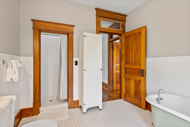 5721 Broomhead Rd, Williamsburg, MI 49690 - bathroom featuring wainscoting, a freestanding bath, and a tile shower