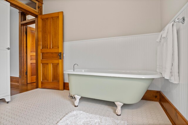 5721 Broomhead Rd, Williamsburg, MI 49690 - bathroom featuring a freestanding bath and a wainscoted wall