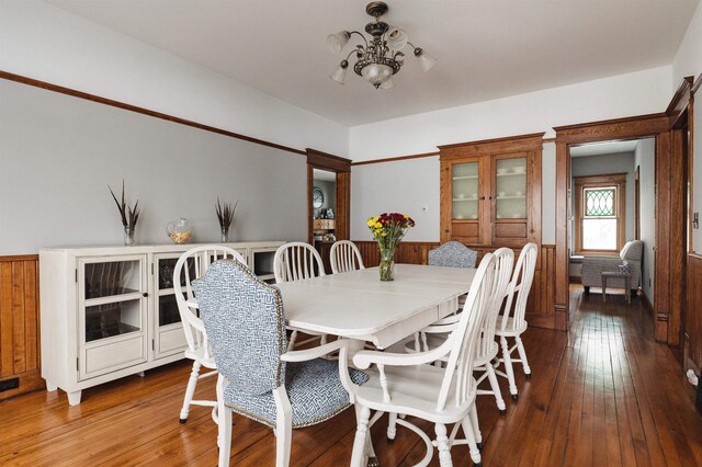 5721 Broomhead Rd, Williamsburg, MI 49690 - dining room with wood-type flooring, a chandelier, and a wainscoted wall