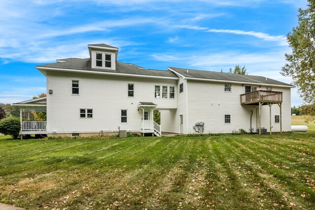 5721 Broomhead Rd, Williamsburg, MI 49690 - rear view of house with a yard and central air condition unit