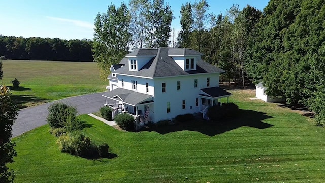5721 Broomhead Rd, Williamsburg, MI 49690 - rear view of property featuring a lawn, driveway, and a garage