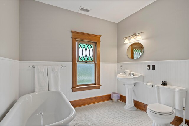 5721 Broomhead Rd, Williamsburg, MI 49690 - full bathroom with a soaking tub, a wainscoted wall, and toilet