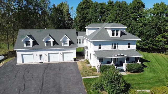 5721 Broomhead Rd, Williamsburg, MI 49690 - view of front of house with a porch, a front yard, and driveway