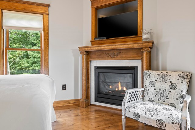 5721 Broomhead Rd, Williamsburg, MI 49690 - bedroom featuring wood finished floors and a tiled fireplace