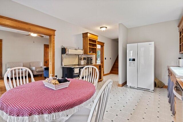5721 Broomhead Rd, Williamsburg, MI 49690 - dining area with ceiling fan, stairway, baseboards, and light flooring