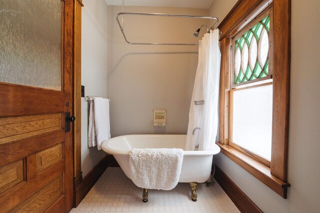 5721 Broomhead Rd, Williamsburg, MI 49690 - full bath featuring a freestanding bath, baseboards, and a shower with curtain