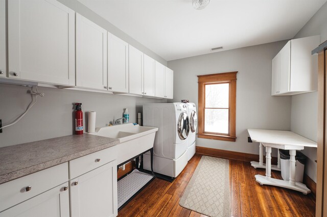 5721 Broomhead Rd, Williamsburg, MI 49690 - laundry room featuring cabinet space, washing machine and dryer, dark wood finished floors, and baseboards