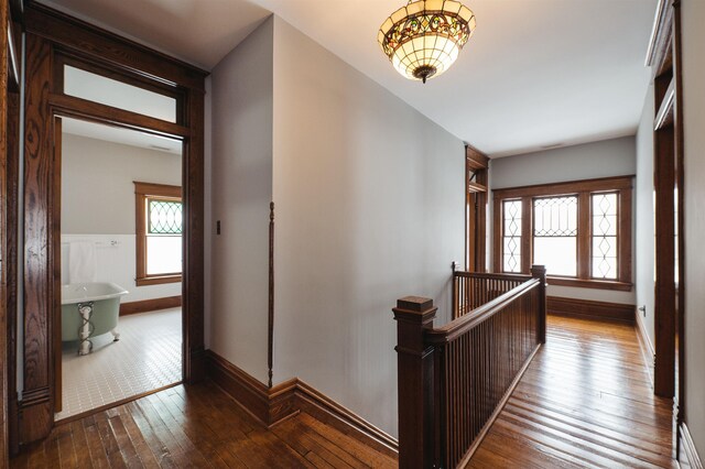 5721 Broomhead Rd, Williamsburg, MI 49690 - hallway with an upstairs landing, wood-type flooring, healthy amount of natural light, and baseboards