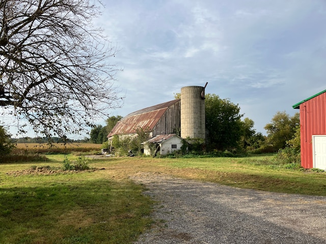 view of side of property with an outbuilding and a rural view