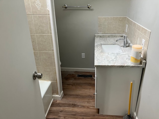 bathroom featuring hardwood / wood-style floors, vanity, and a tub to relax in