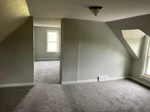 bonus room with carpet flooring and vaulted ceiling