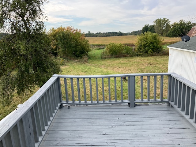 wooden terrace with a lawn and a rural view