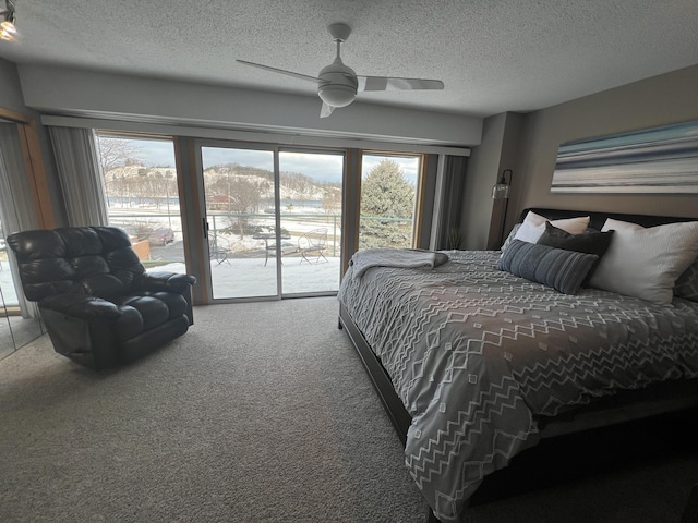 bedroom with ceiling fan, access to exterior, carpet, and a textured ceiling