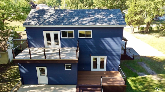 rear view of house featuring french doors, a yard, a balcony, and a wooden deck