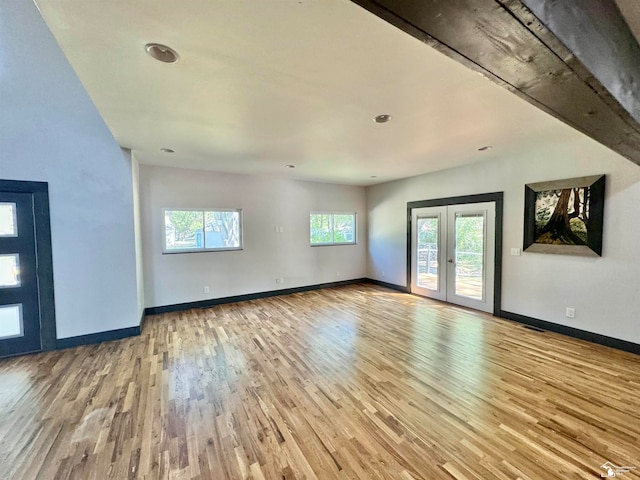 unfurnished living room with french doors and light hardwood / wood-style floors