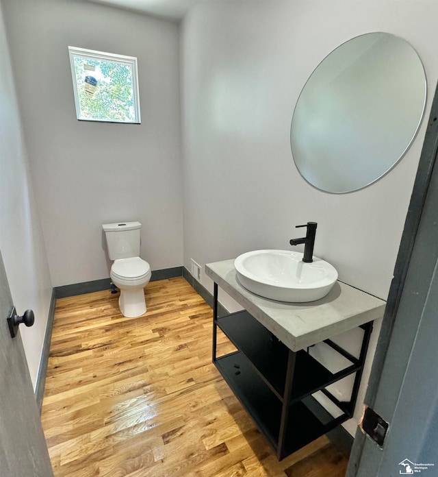 bathroom featuring hardwood / wood-style flooring, toilet, and sink