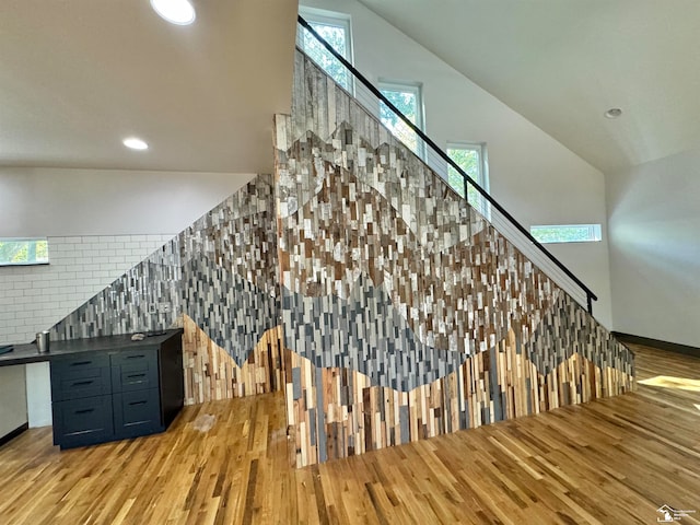 staircase with hardwood / wood-style flooring and vaulted ceiling