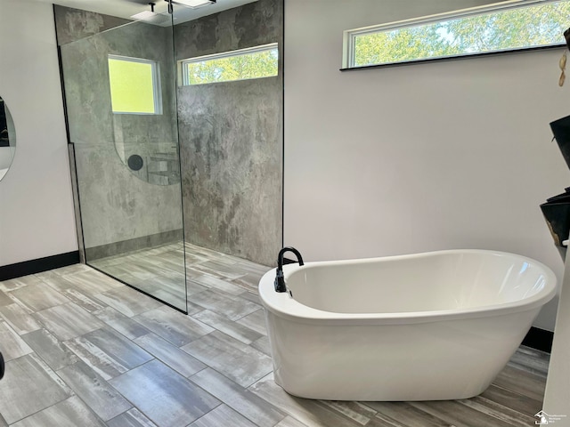 bathroom featuring independent shower and bath and a healthy amount of sunlight