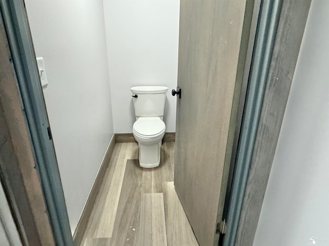 bathroom with hardwood / wood-style floors and toilet