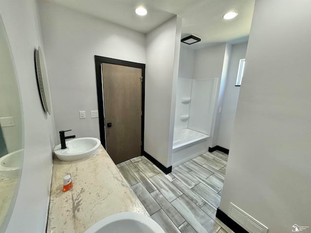 bathroom featuring washtub / shower combination and vanity