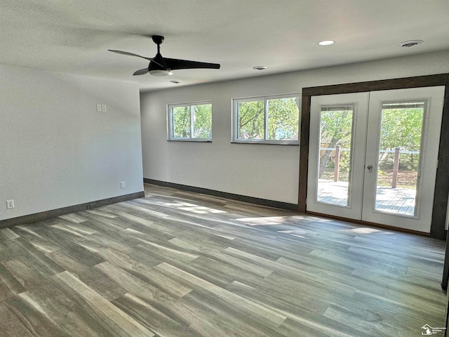 empty room featuring french doors, ceiling fan, and wood-type flooring