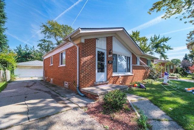 view of front of property featuring a garage, an outbuilding, and a front lawn