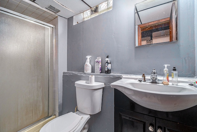 bathroom featuring vanity, toilet, and a shower with door