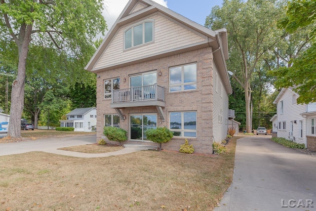 view of front of house featuring a balcony and a front yard