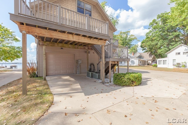 view of property exterior featuring a garage and a wooden deck