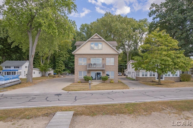 view of front of home featuring a balcony and a front lawn