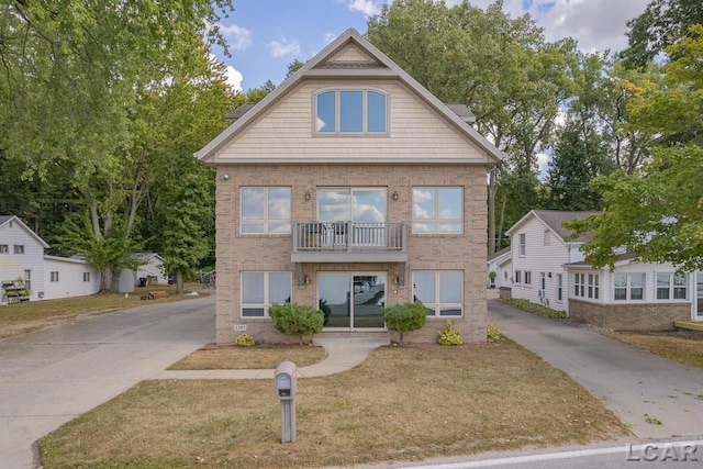 view of front of home featuring a balcony and a front lawn