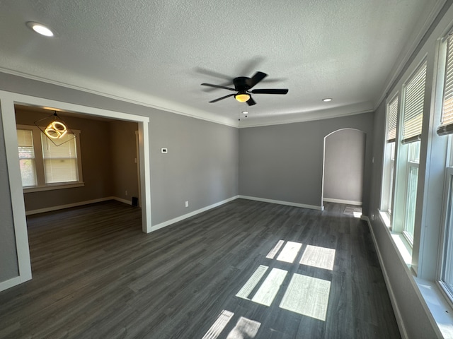 spare room featuring dark hardwood / wood-style floors, ceiling fan, ornamental molding, and a textured ceiling